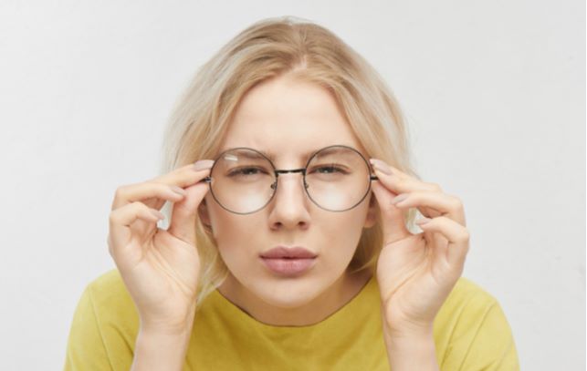 Young women wearing glasses and squirting eyes due to myopia