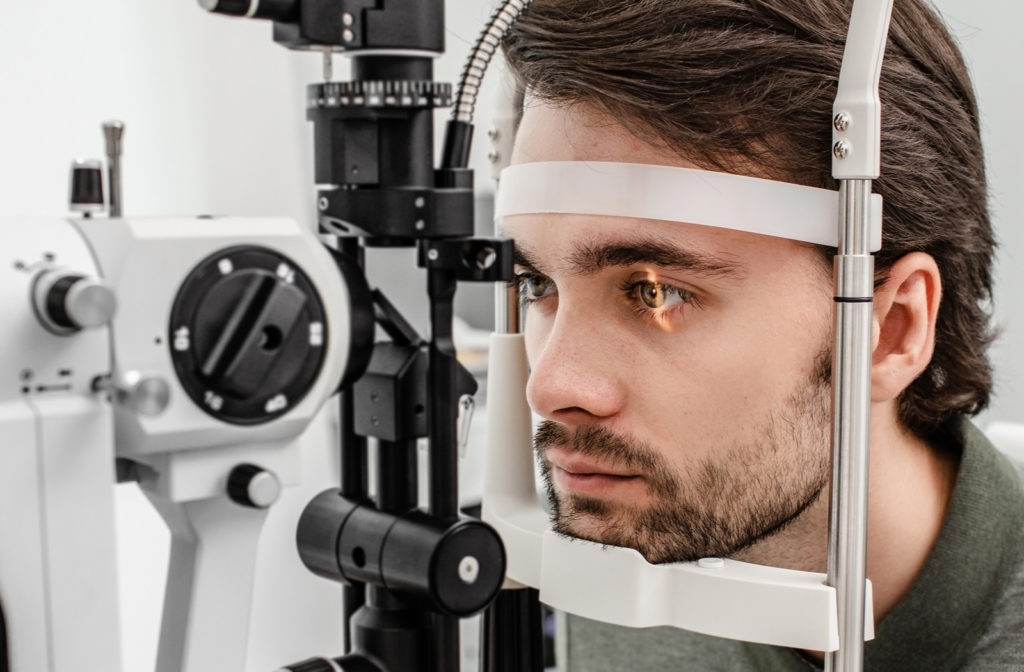 Young man undergoing eye exam at optometrist office