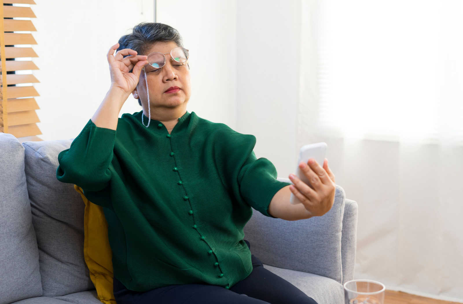 Woman with farsightedness holds out her phone further to better see it.