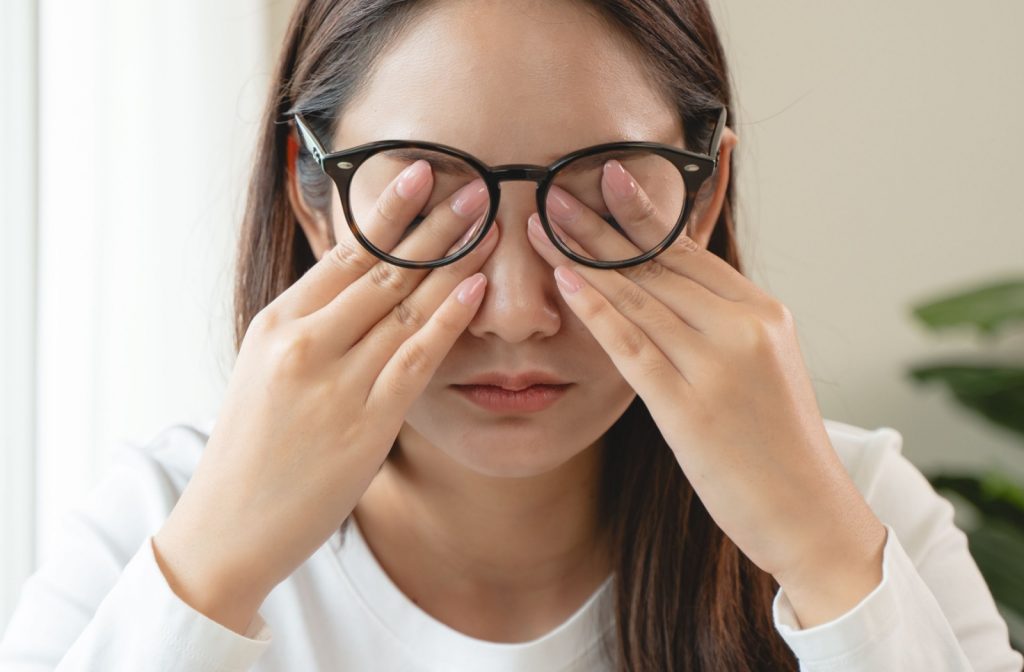 Woman with dry eye symptoms rubbing her eyes.